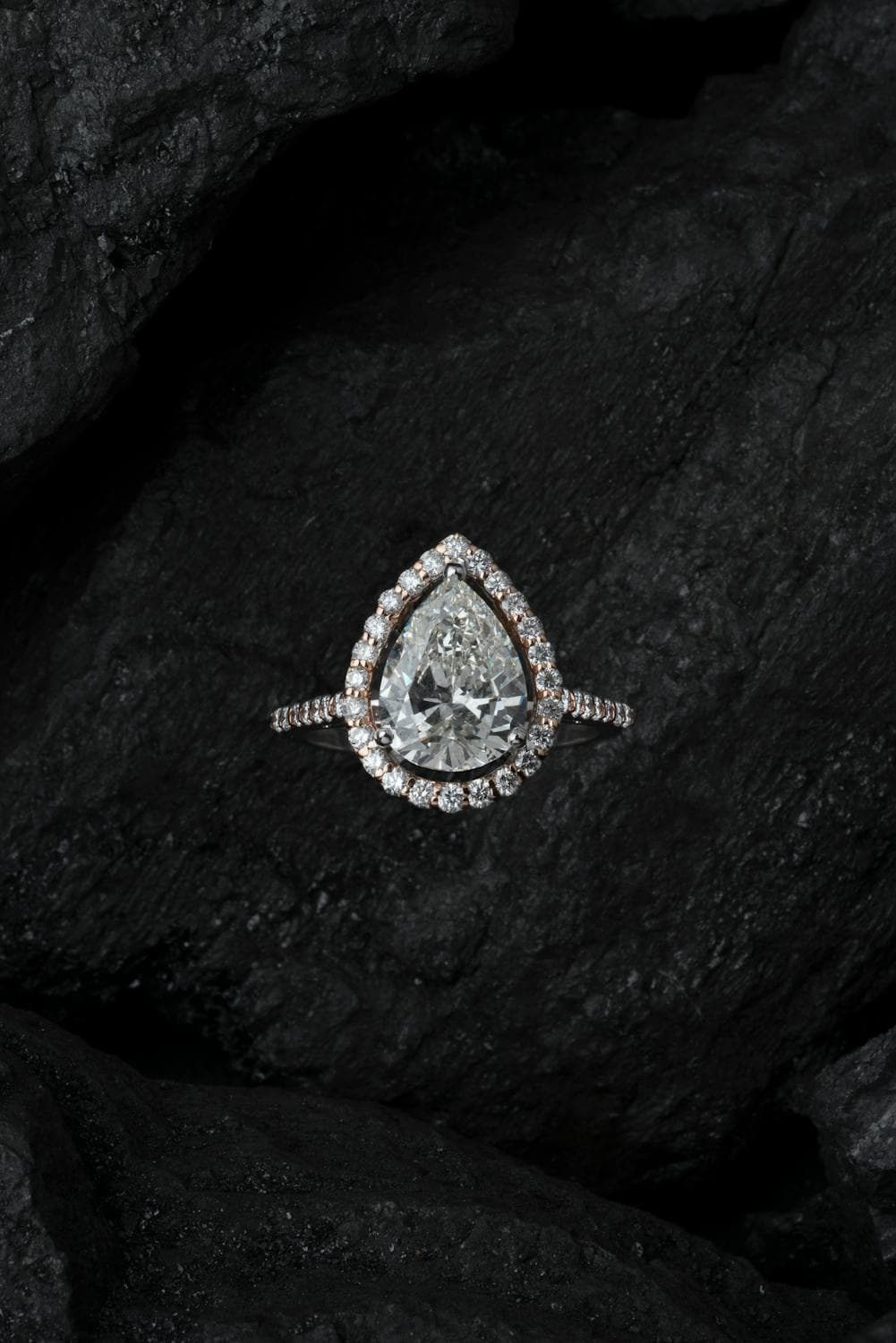 Pear-shaped diamond halo ring on dark surface